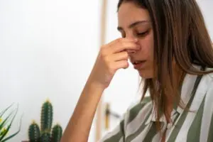 woman holding nose