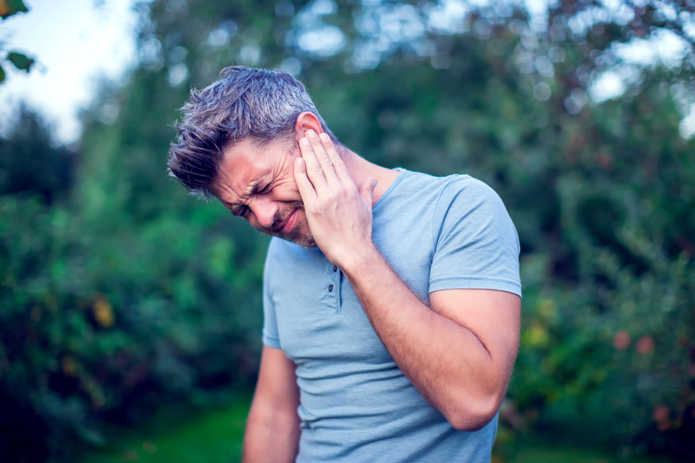 man experiencing ear pain.