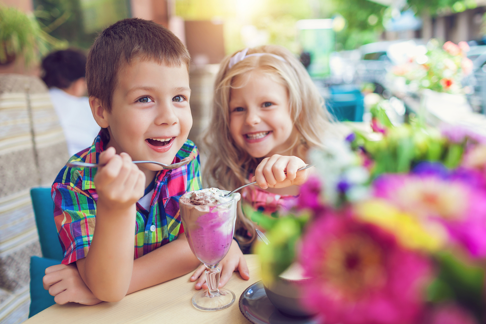 Two kids sharing ice cream.