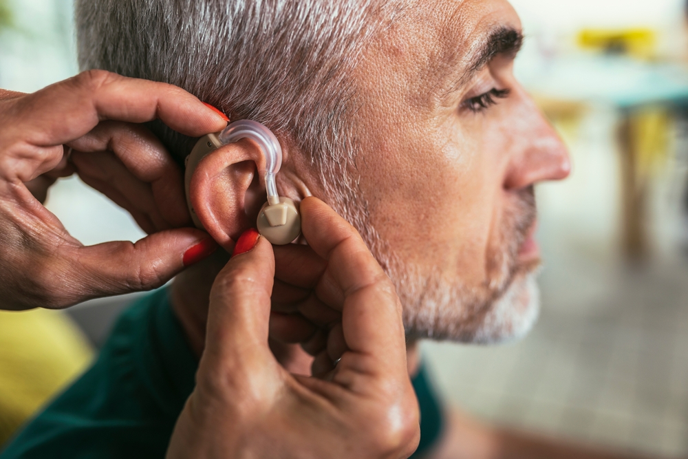 Man receiving a hearing aid.