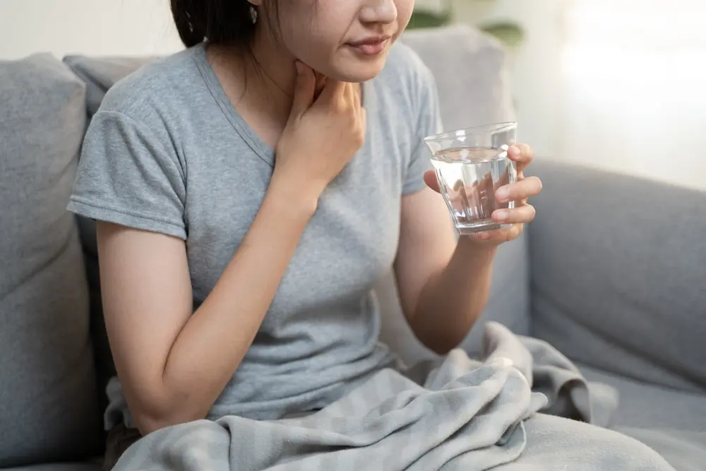 Woman experiencing painful swallowing.